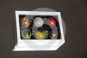 a white paper bow of luxurious chocolate pralines designed as planets