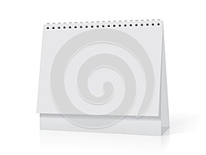 A white paper calendar stands on the table