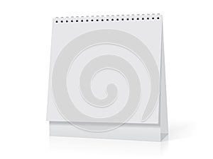 A white paper calendar stands on the table