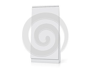 A white paper calendar stands on the table