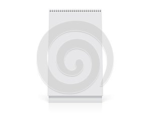 A white paper calendar stands on the table