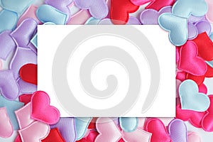 White paper card on colorful pastel heart shaped background. Mock up of greeting card or invitation on Valentine's Day