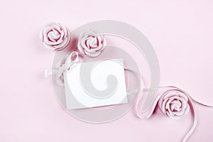 White paper card decorated with pink bow and rose scented candle