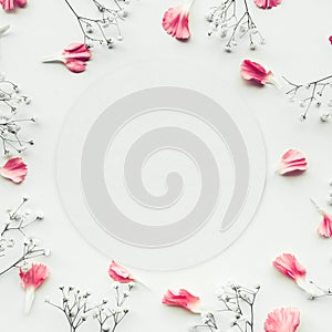 White paper card with petal flower on white background. Flat lay.