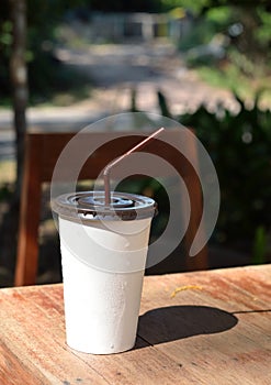 White paper cup with drinking straw.