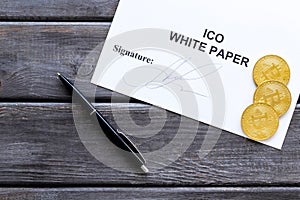 White paper ICO, coins, pen on wooden background top view