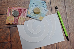 White paper and Indonesian Rupiah isolated on wooden table. finance and retirement concept