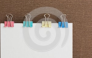 White paper note with colorful paper clips