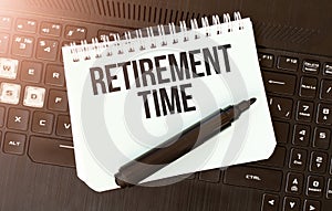 White paper sheet with text retirement time on the black laptop