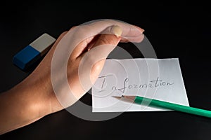 White paper sheet with word `Information` and pencil are on the black background. Female hand is protecting information, near is e