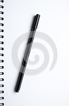 White paper spiral notebook and black pen