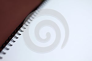 White paper spiral notebook on brown background