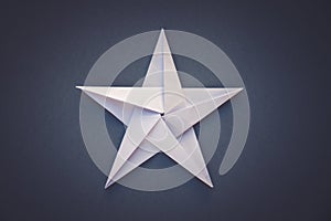 White paper star origami isolated on a grey background