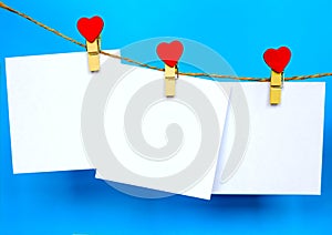 White paper stickers hanging on heart shape pins and pack-thread