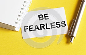 White paper with text Be Fearless on a yellow background with stationery