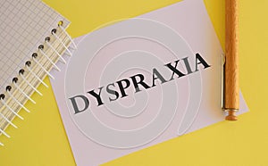 White paper with text Dyspraxia , difficulties with physical movement and memory, dyspraxia concept, random letters around, white