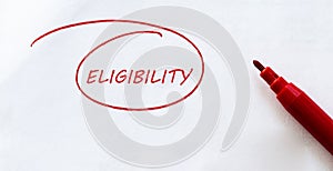 White paper with text Eligibility on the white with red marker photo