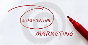 White paper with text Experiential Marketing on the white with red marker