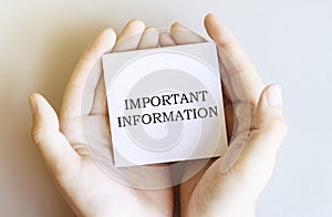 White paper with text Important Information in male hands on a white background