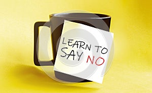 White paper with text Learn To Say No on the black cup