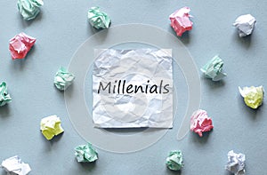 White paper with text Millenials on the blue background with a lot of another paper photo