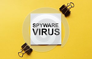 White paper with text Spyware virus on a yellow background with stationery