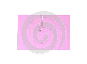 A white paperclip with blank pink notepaper. Pink sheet for your message or adding more text. Memo note with paper clip