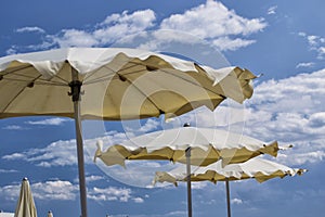 White parasols with blue sky and clouds. for summer seascape concept