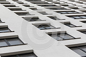 White parget wall on modern concrete building facade ground view