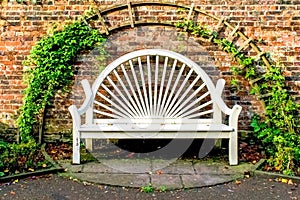 White Park Bench Seat against old brick wall