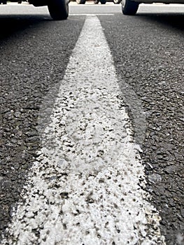 White parking lane line with two wheels in background