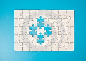 White part of jigsaw puzzle pieces on blue background. concepts of problem solving, business success, teamwork, Team playing