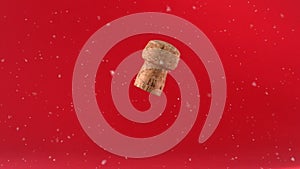 White particles floating over wine cork falling against red background