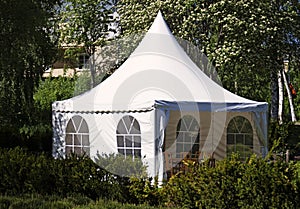 A white party tent spread out on the lawn