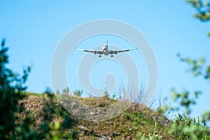 White passenger aircraft approaching the runway under the blue sky