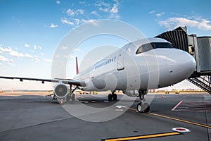 A white passenger airliner at the jetway