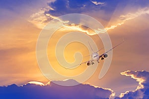 White passenger airplane flying away in to sky high altitude with iridescence cloud or rainbow cloud