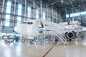 White passenger airplane in the hangar. Airliner under maintenance