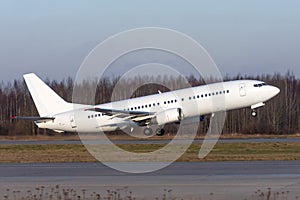 White passenger commercial plane takes off from runway side view