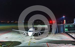 White passenger jet plane on runway at night