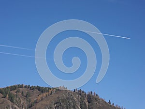 White passenger jets flying in the blue sky.