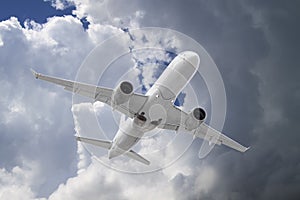 white passenger plane flies against backdrop of beautiful ominous clouds on blue sky background