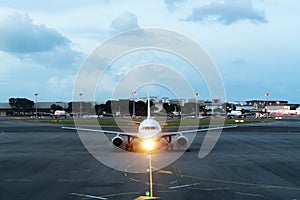 White passenger plane takes off from the airport runway. Aircraft moves against the backdrop of night. Airplane front view. photo