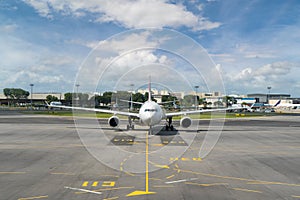 White passenger plane takes off from the airport runway. Airplane front view.