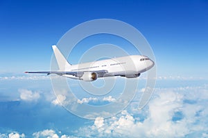 White passenger wide body plane. Aircraft is flying in blue cloudy sky