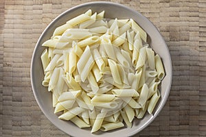 White pasta on a brown bowl wooden background top view photo