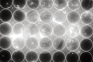 White pattern of transparent spheres on a black background.