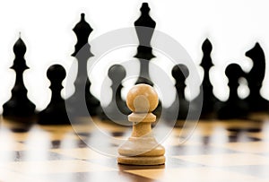 White pawn against a superiority of black chess pieces