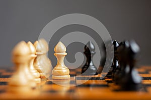 White pawn, in front of black, on a chessboard. Selective focus. Correct move. Strategy. Sport. Business