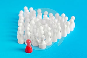 White pawns following red one on light blue background. Social inclusion concept